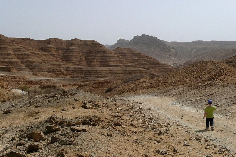 Child walking in desert canyon