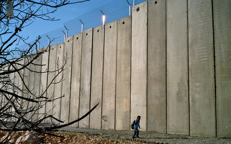 Child walking near concrete wall