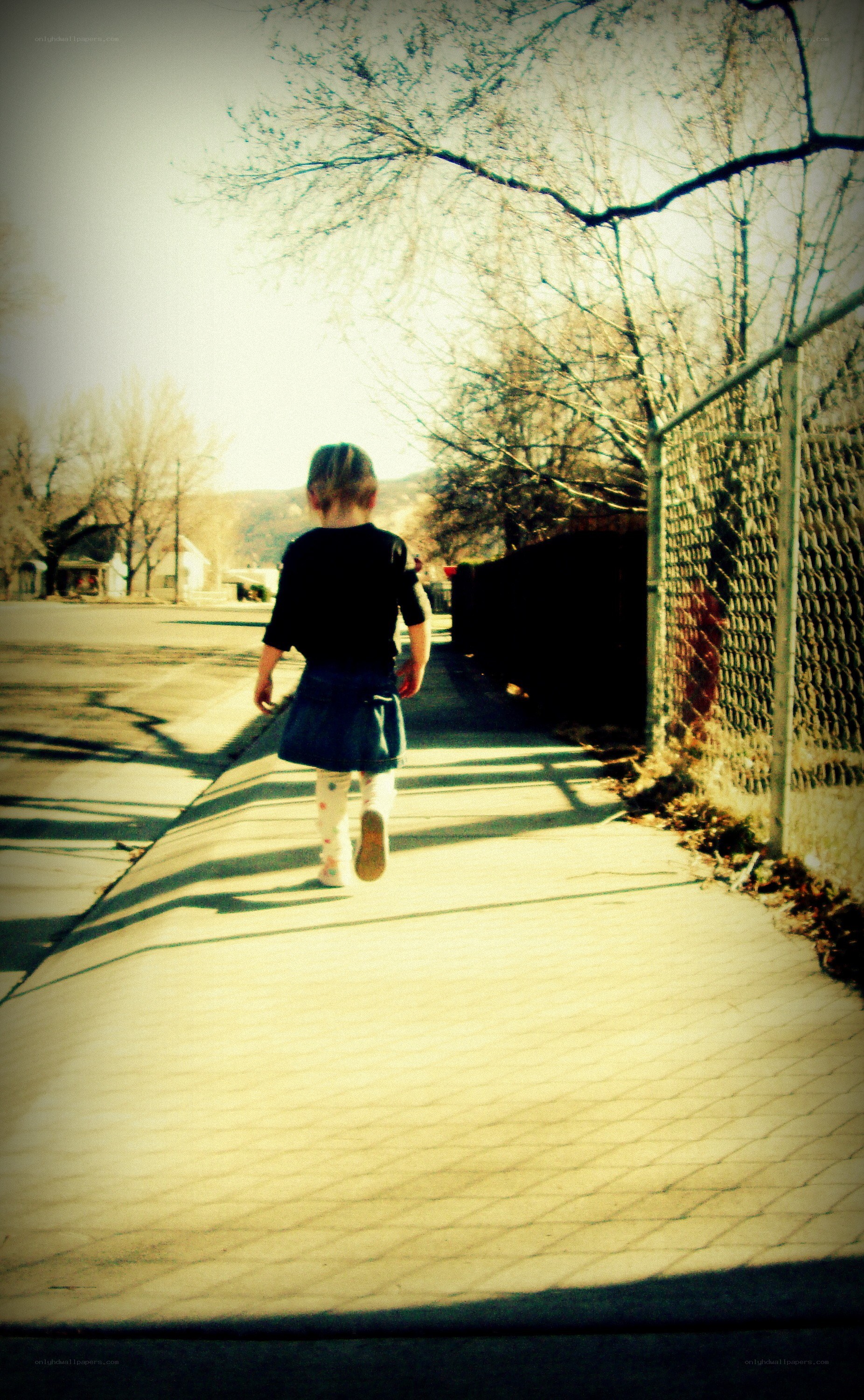 child walking on sidewalk