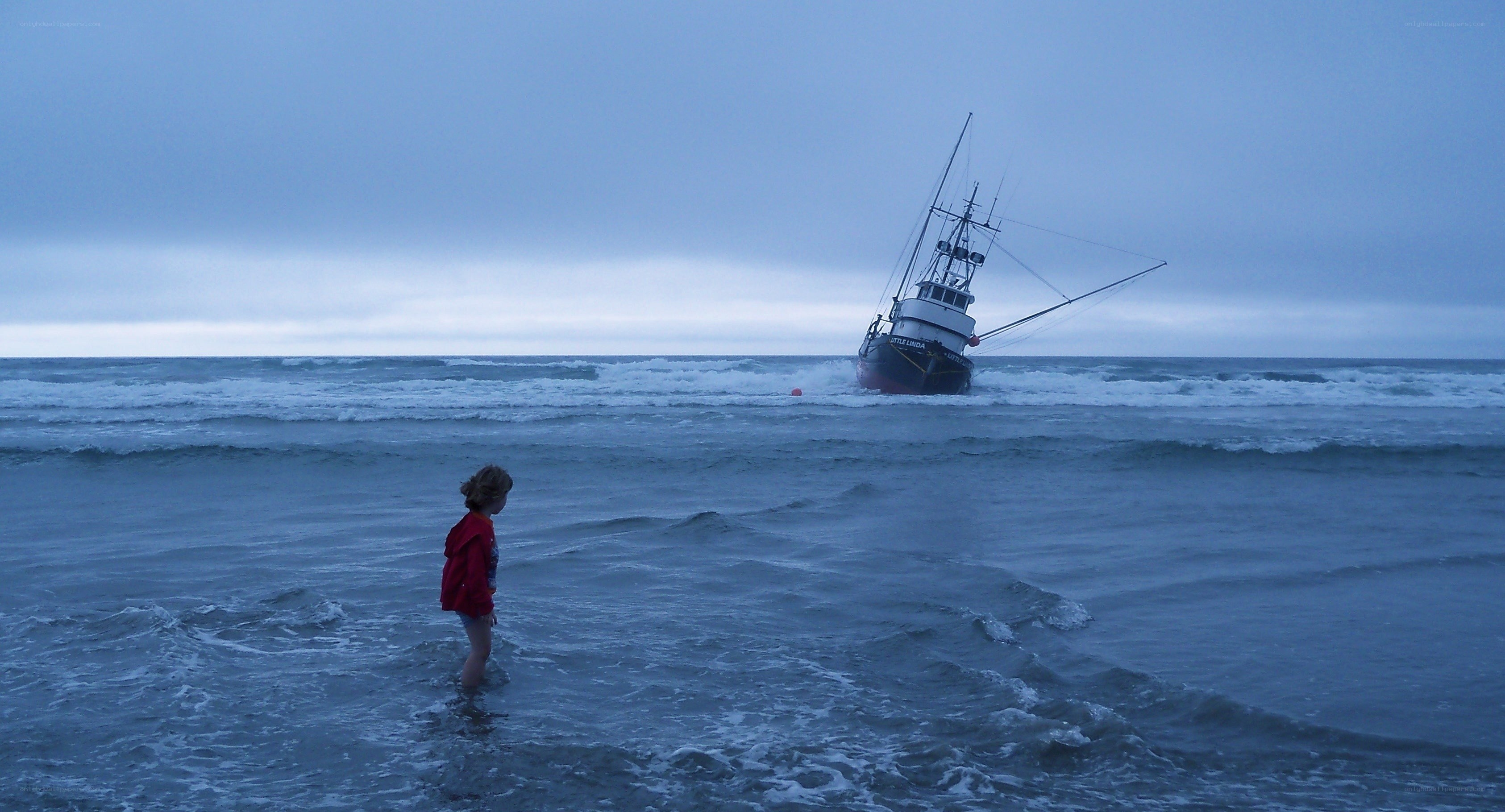 Child watches shipwreck at sea