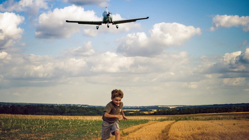 Child watching plane fly overhead