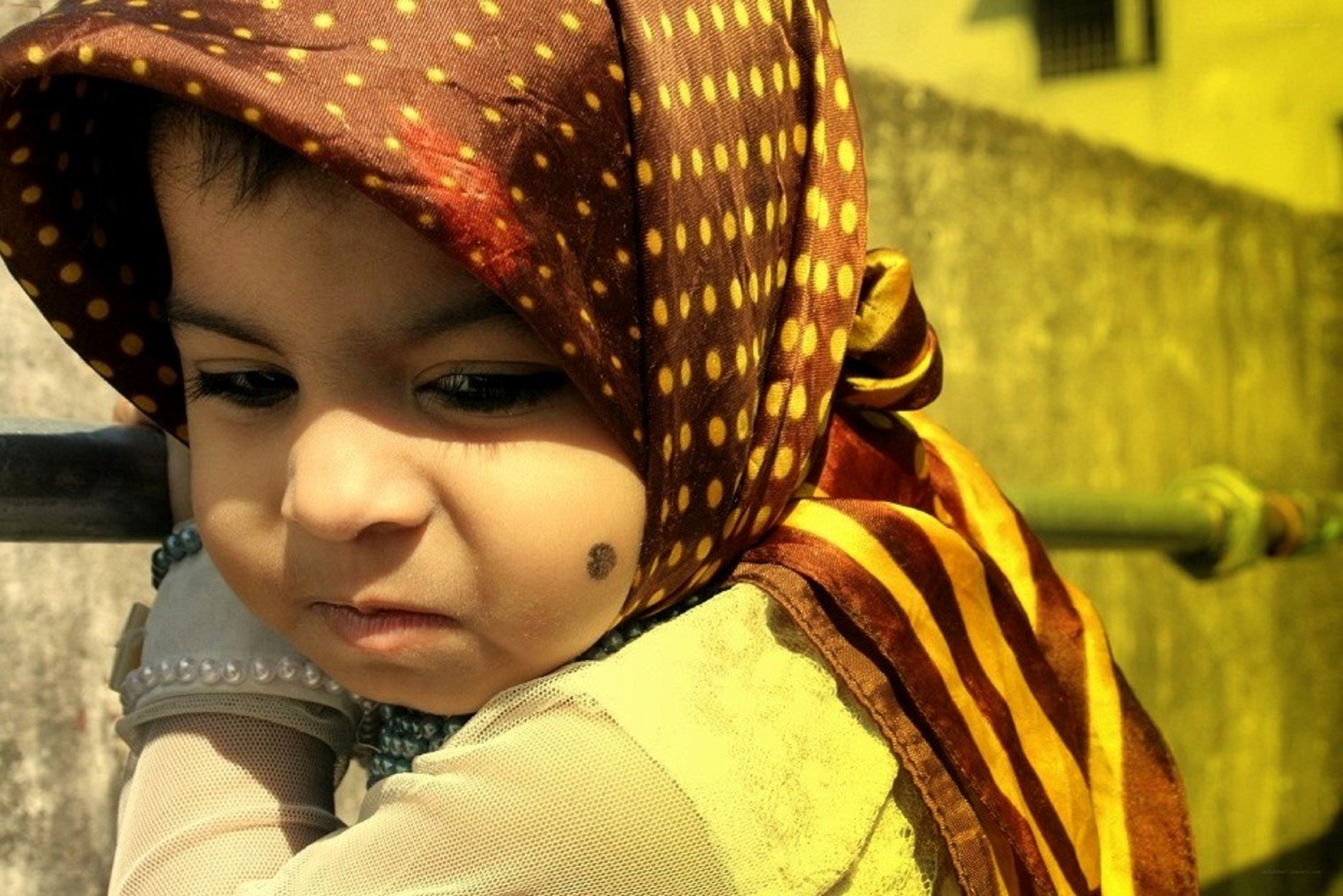 child wearing polka-dot headscarf