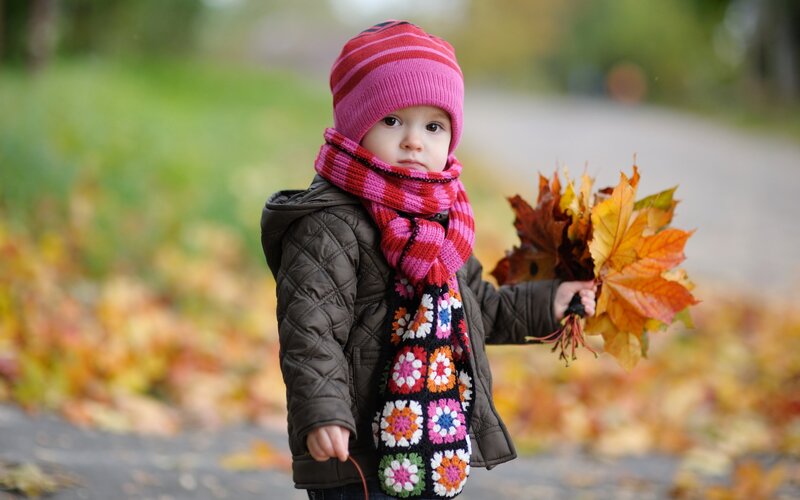 child with autumn leaves