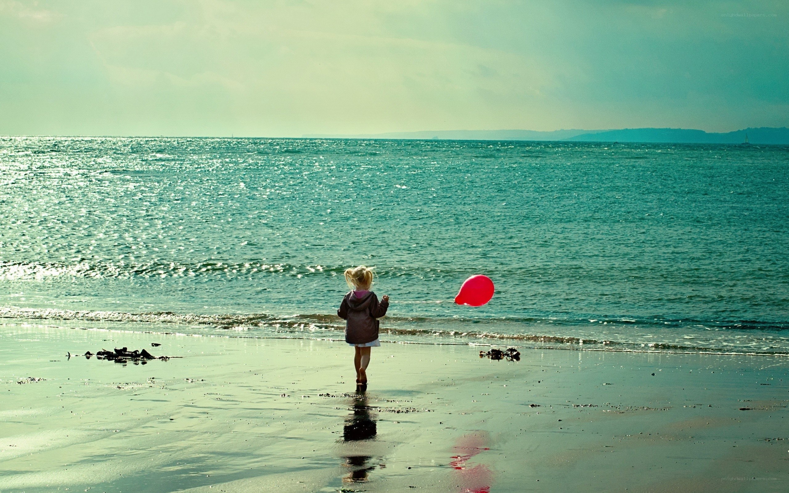 child with balloon at beach