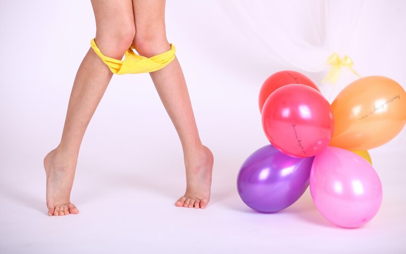 child with balloons and yellow underwear