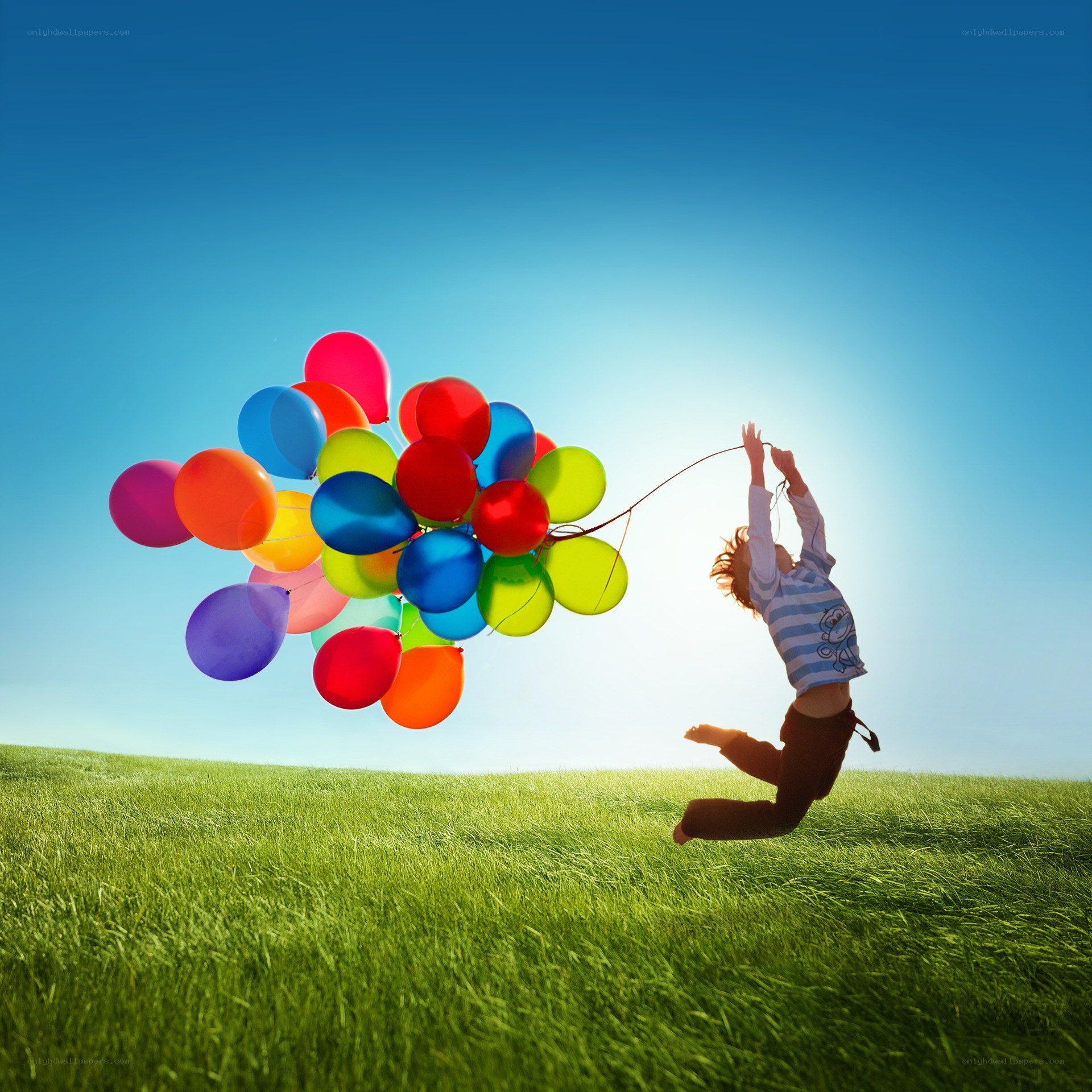 Child with balloons in field