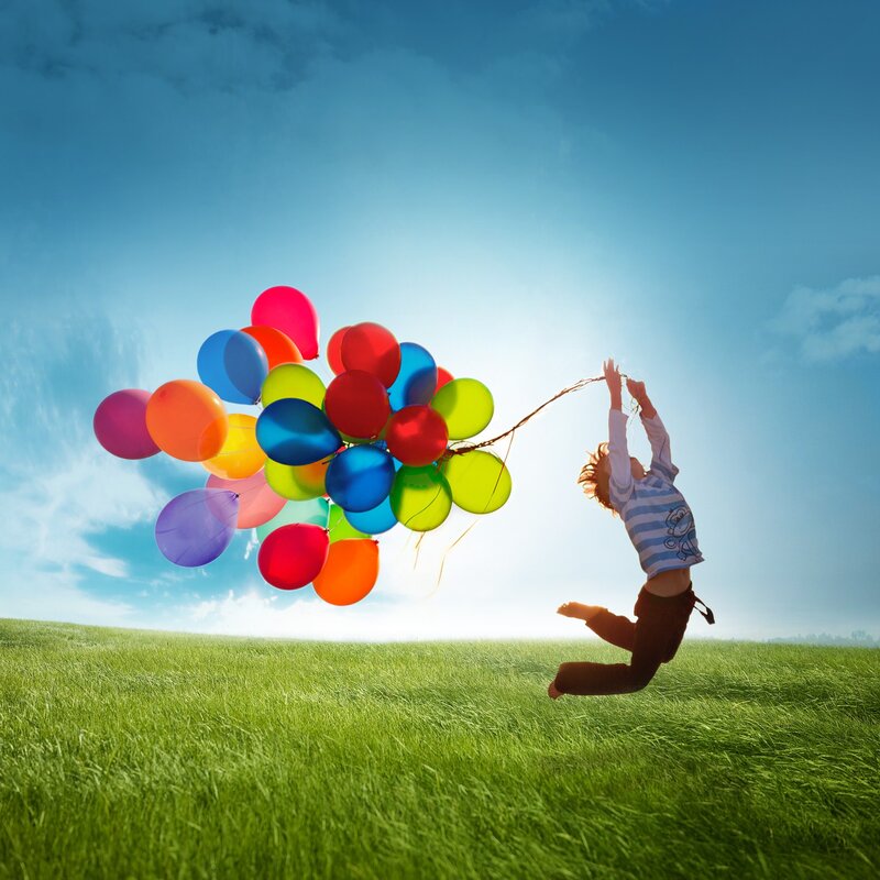 Child with balloons in field