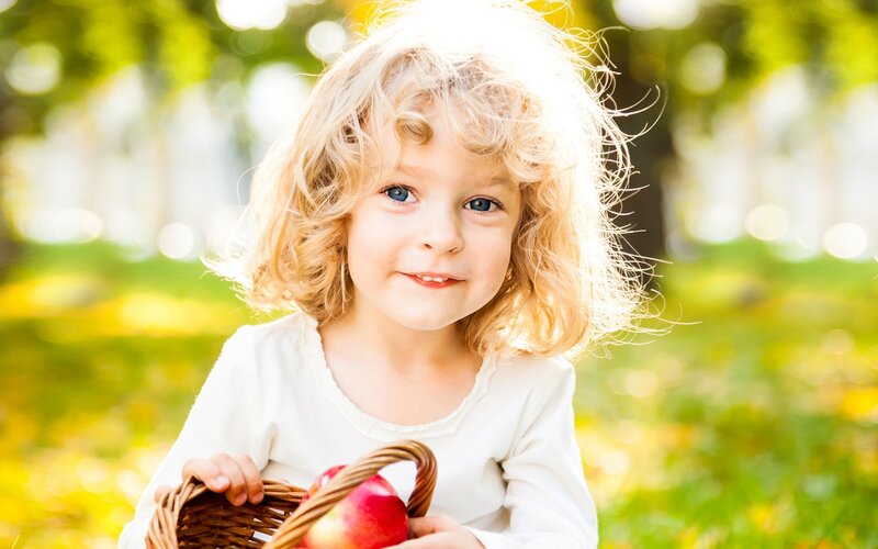 child with basket of apples