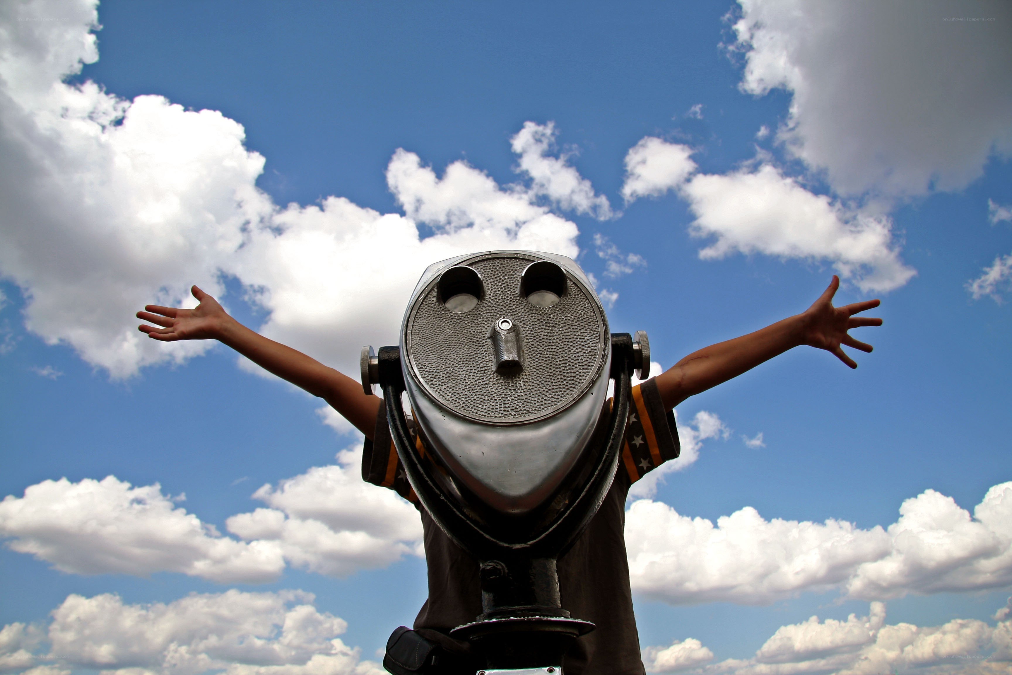 Child with binoculars against sky