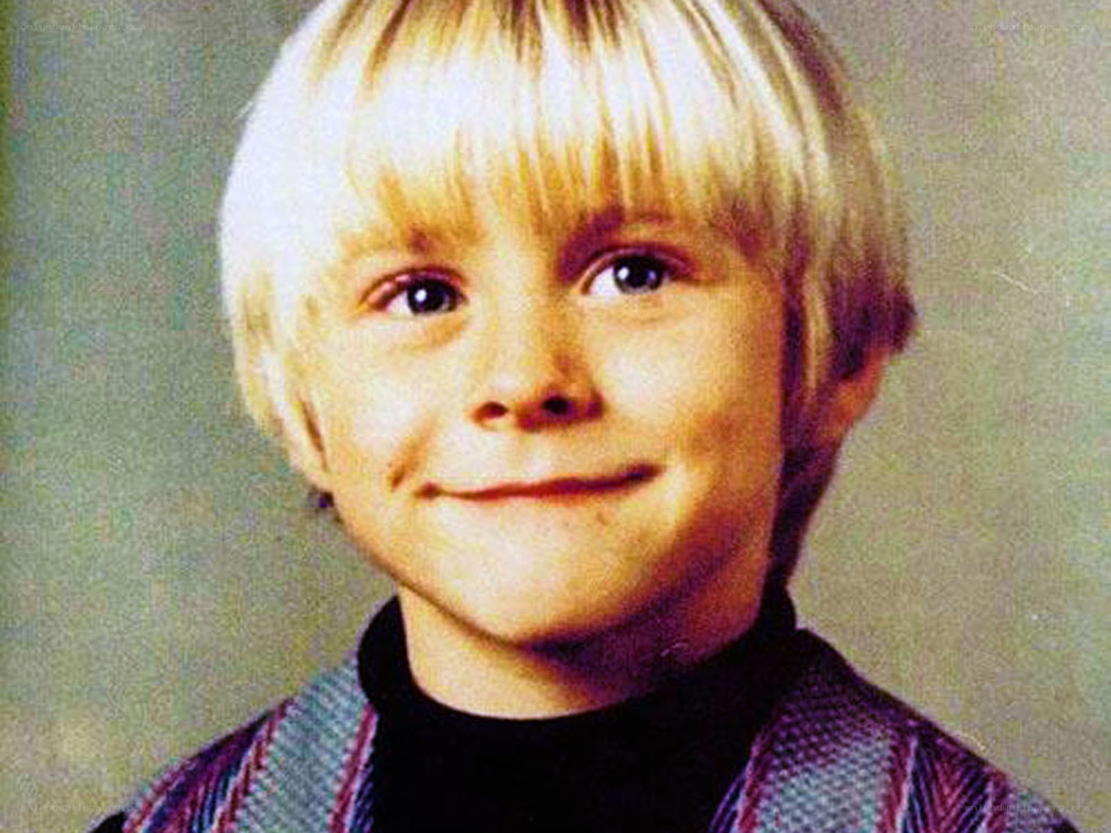 child with blonde hair smiling