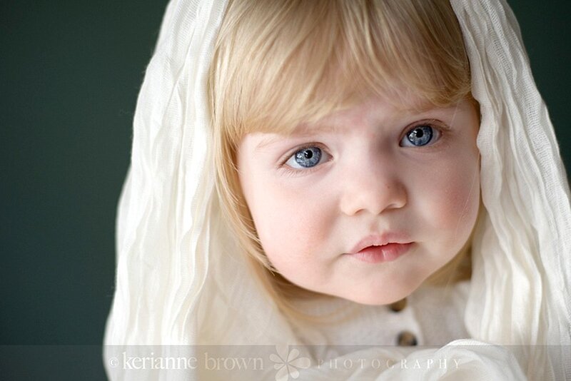 child with blue eyes and white veil