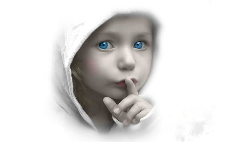 child with blue eyes making shush gesture
