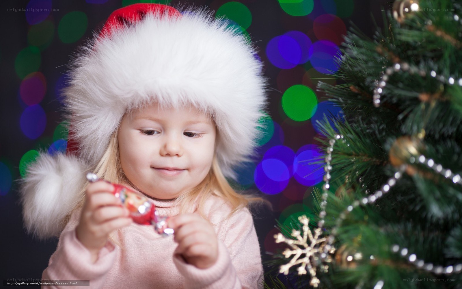 child with candy near christmas tree