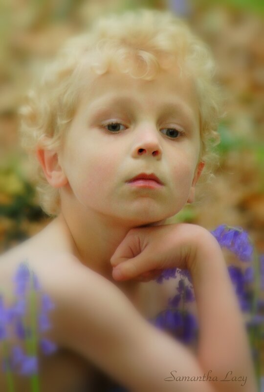 child with curly hair in flowers