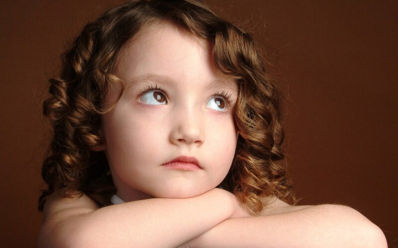 child with curly hair looking up