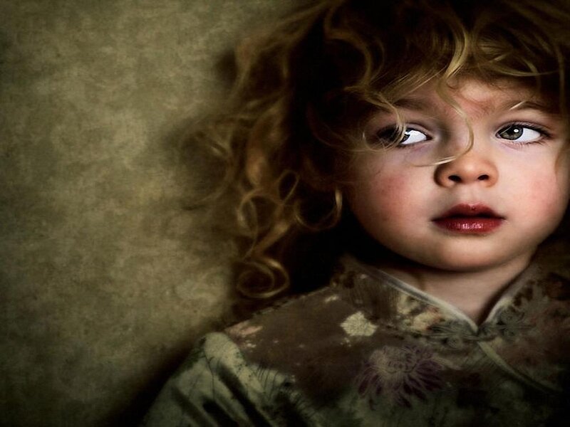 child with curly hair looking up