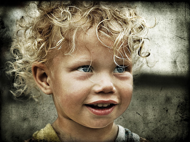 child with curly hair smiling