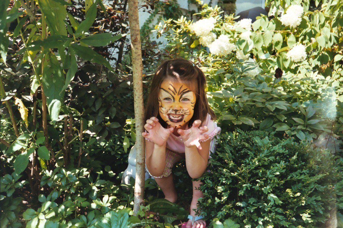 Child with face paint in garden