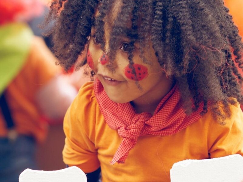 Child with Face Paint — Orange