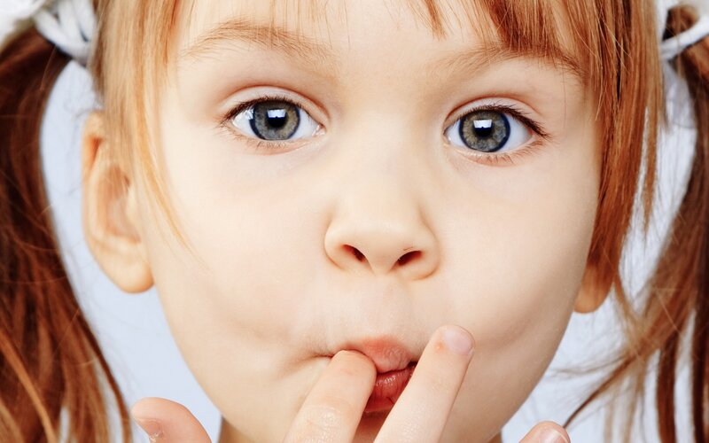 child with fingers in mouth