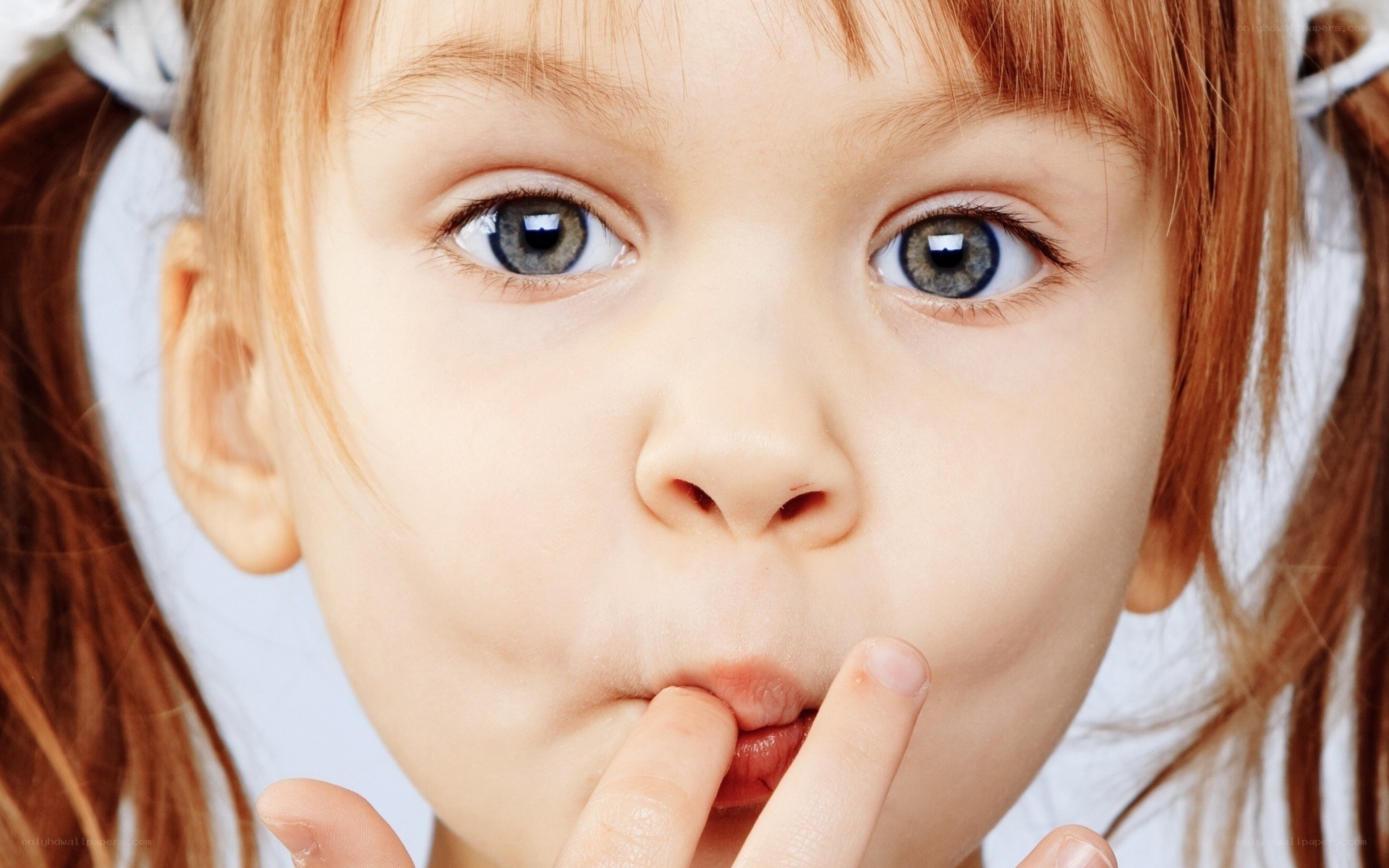 child with fingers in mouth