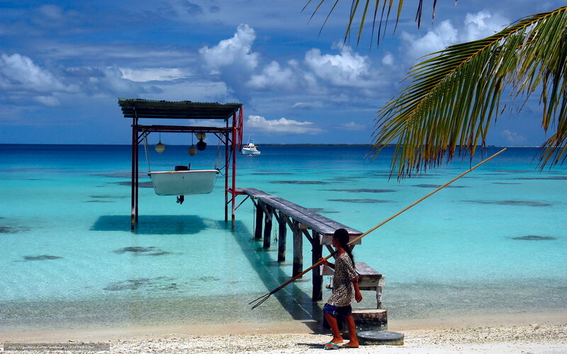 Child with fishing spear on tropical beach