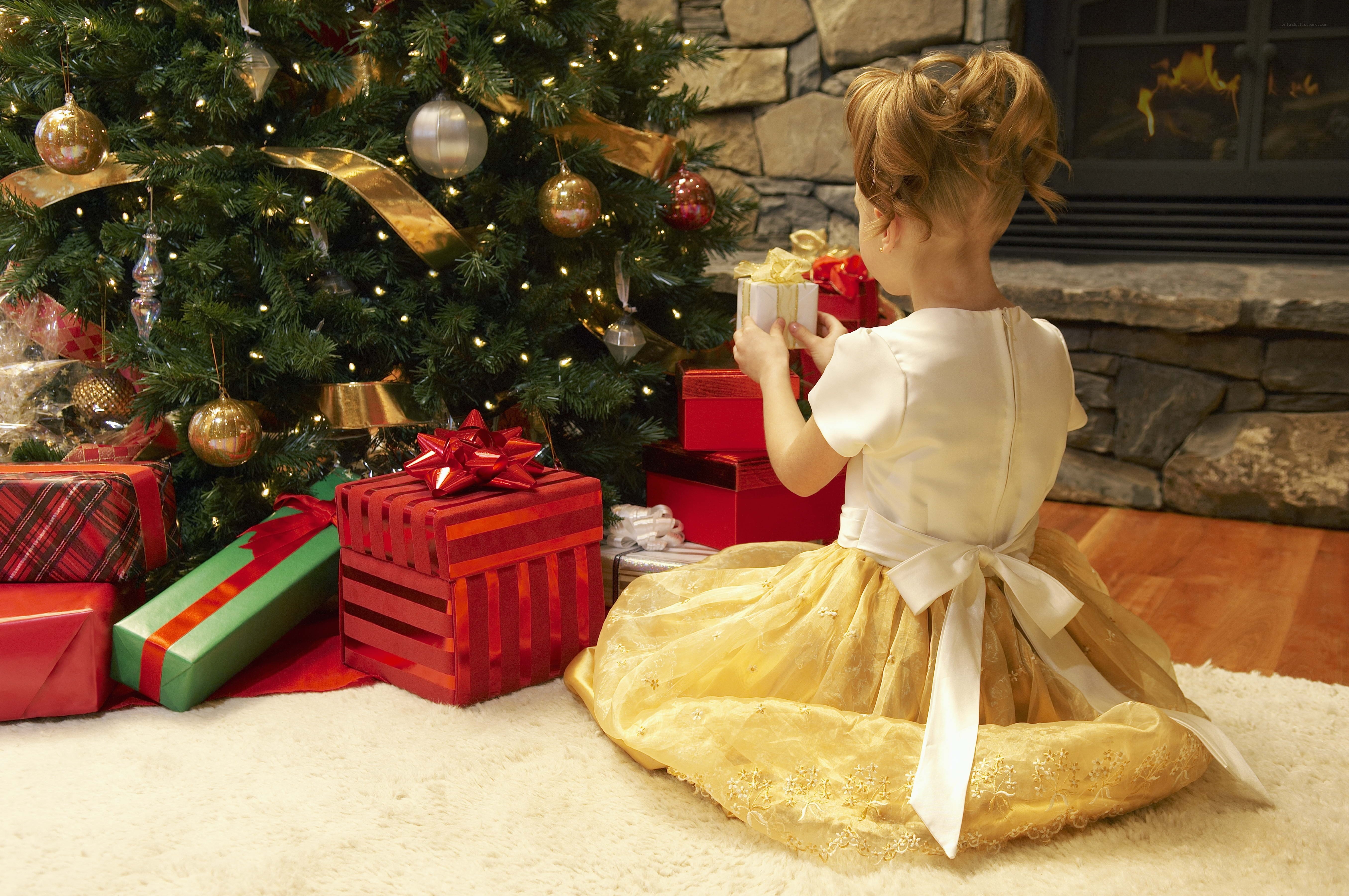 child with gift near christmas tree