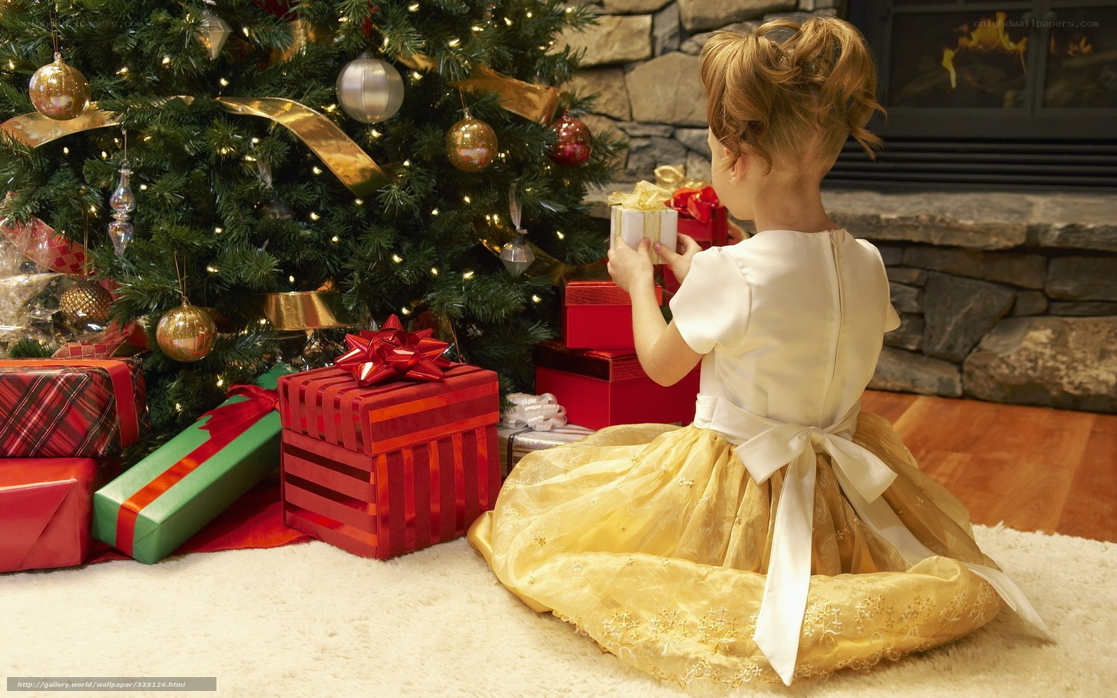 child with gifts by christmas tree