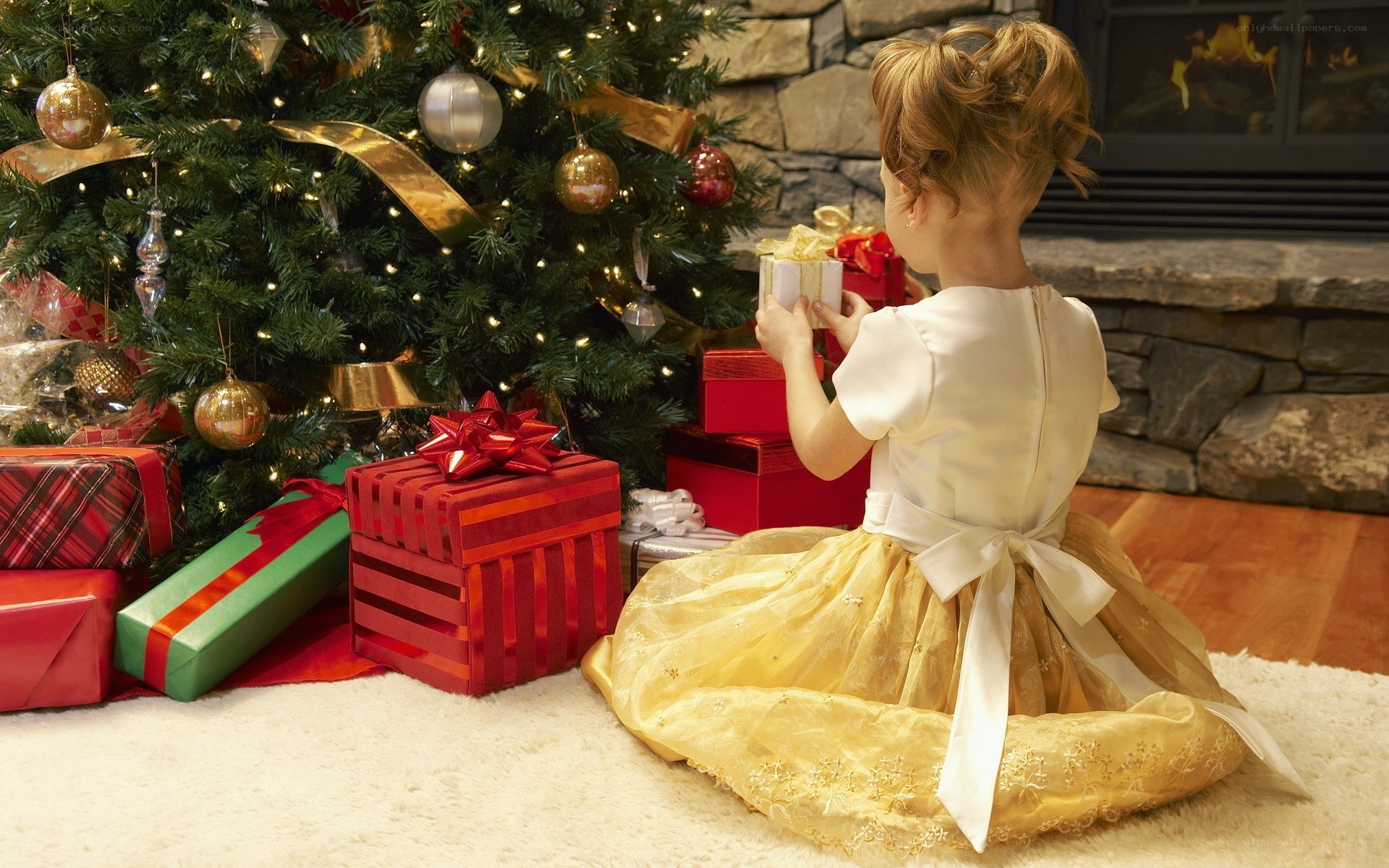 child with gifts by tree