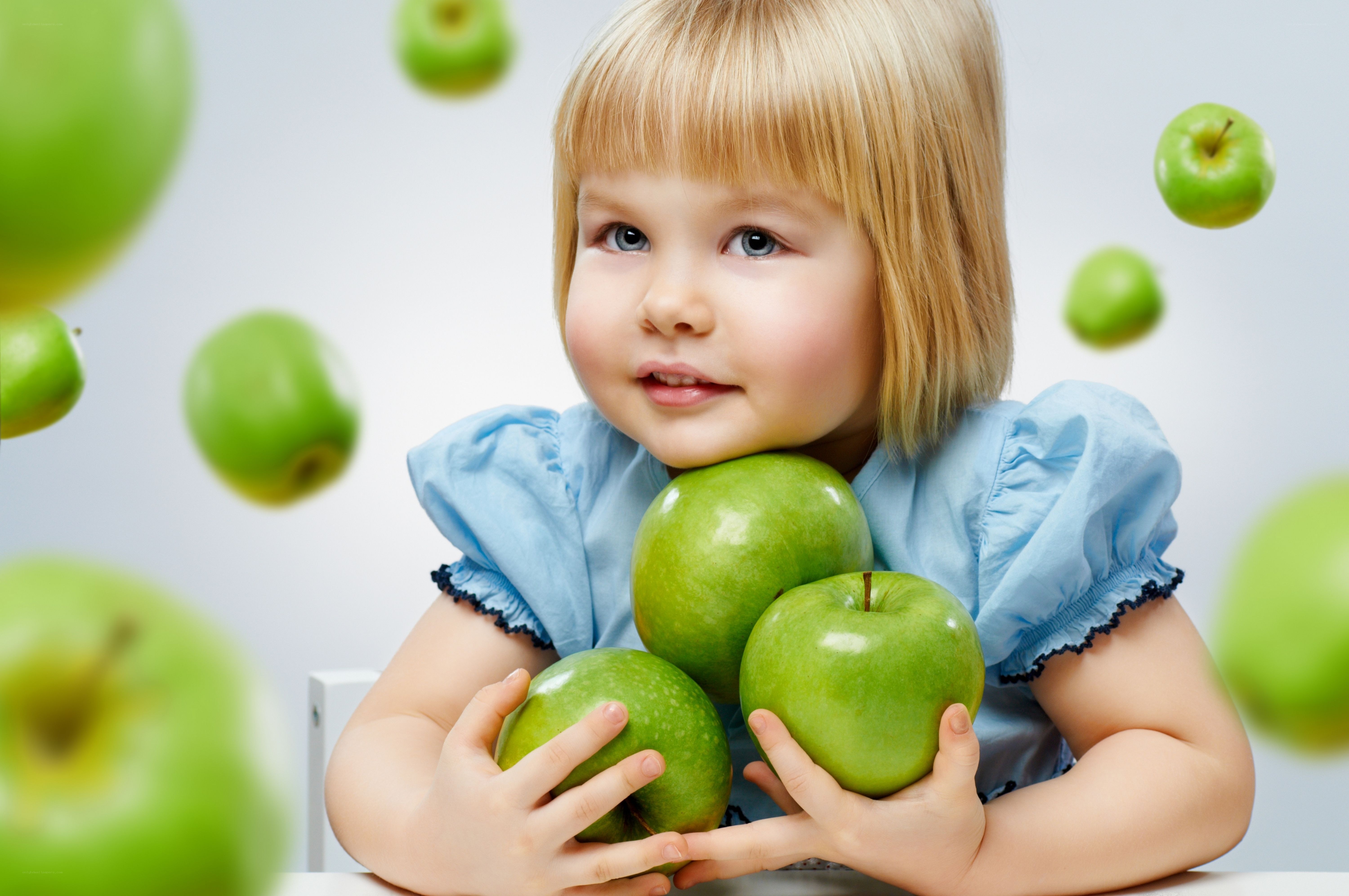 child with green apples