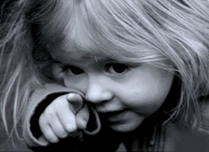 Child with Hand Near Face — Black