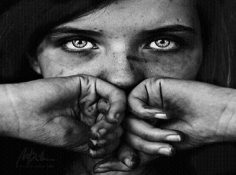 child with hands covering mouth
