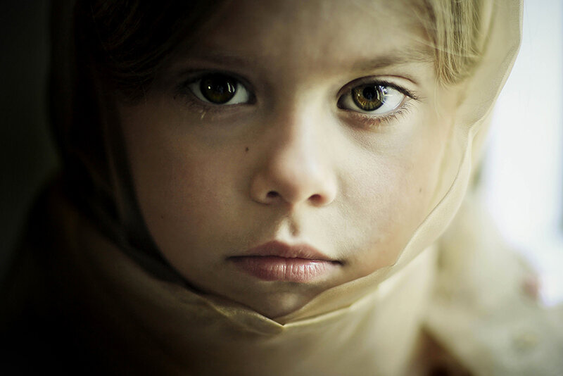 child with headscarf looking at camera