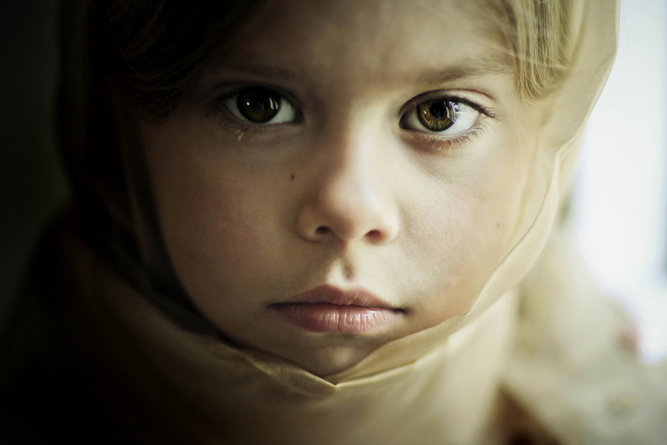child with headscarf looking at camera