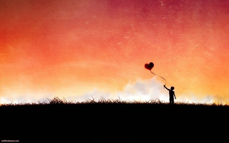Child with heart balloon at sunset