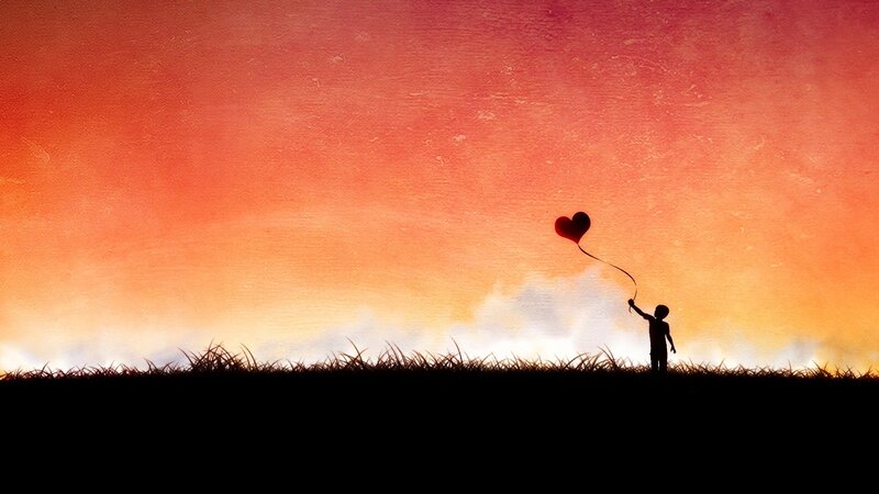 child with heart balloon at sunset