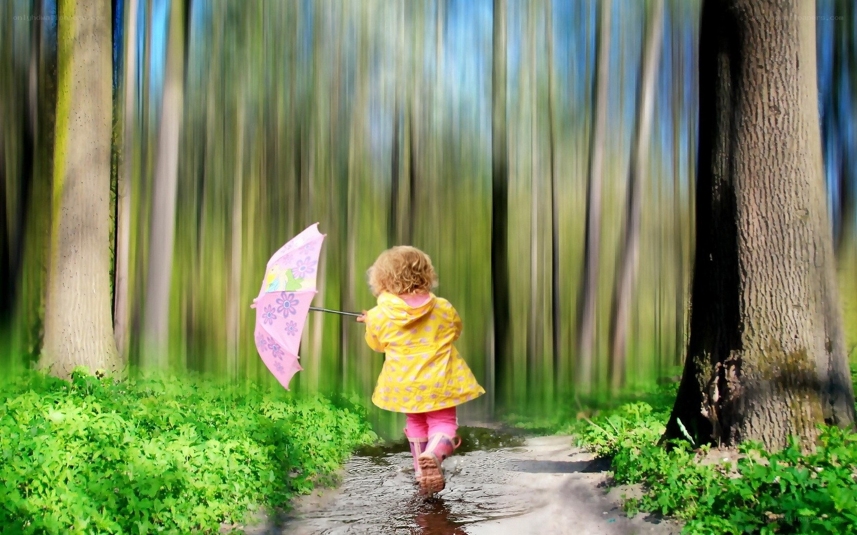 child with pink umbrella in forest