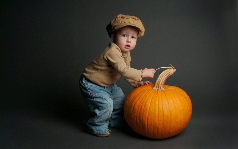 child with pumpkin in studio