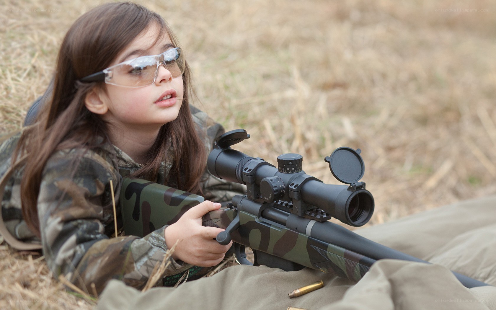 child with rifle in field