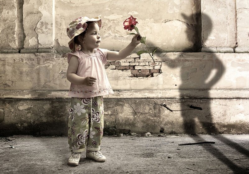child with rose in old alley