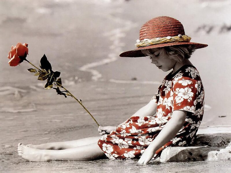 Child with rose on beach