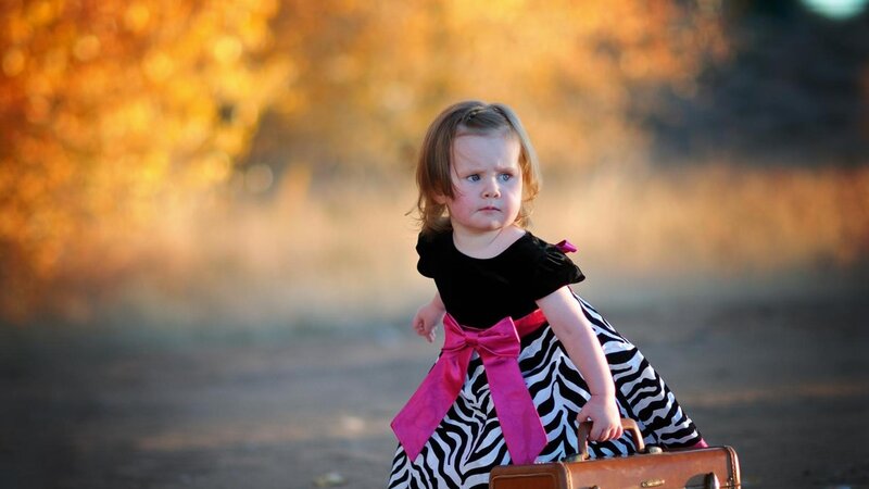 child with suitcase in autumn
