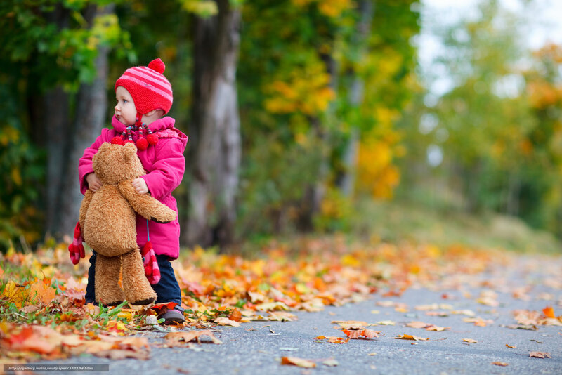 Child with teddy bear in autumn