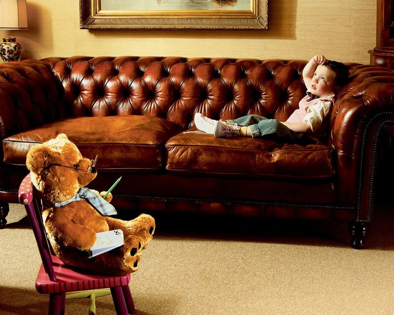 Child with teddy bear on sofa