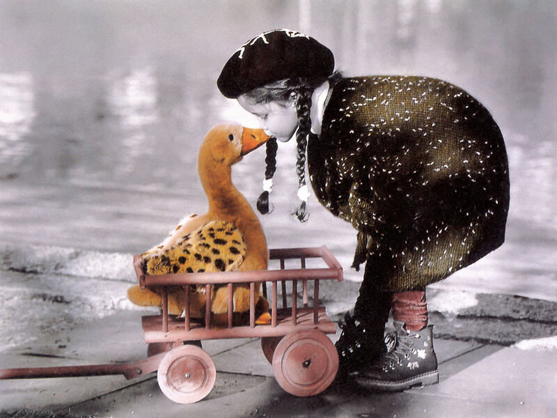 child with toy duck in cart