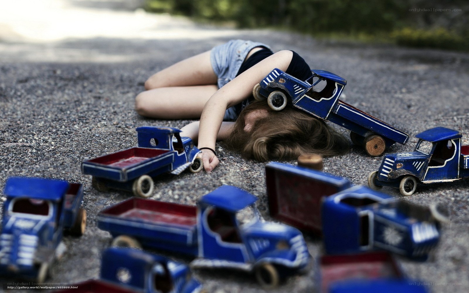 Child with toy trucks on ground