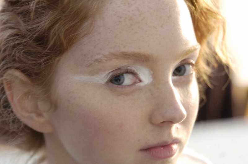 child with white eye makeup