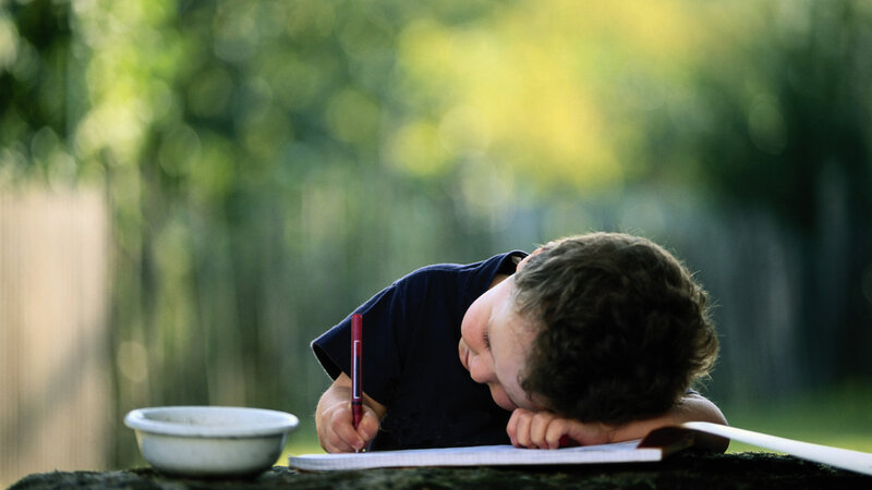 Child Writing at Table — Green
