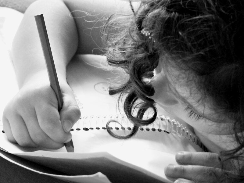 Child Writing in Notebook — Black
