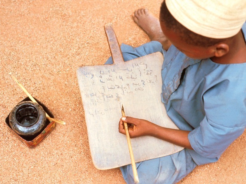 child writing on a board